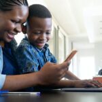 mother and son using smartphone at home for learning