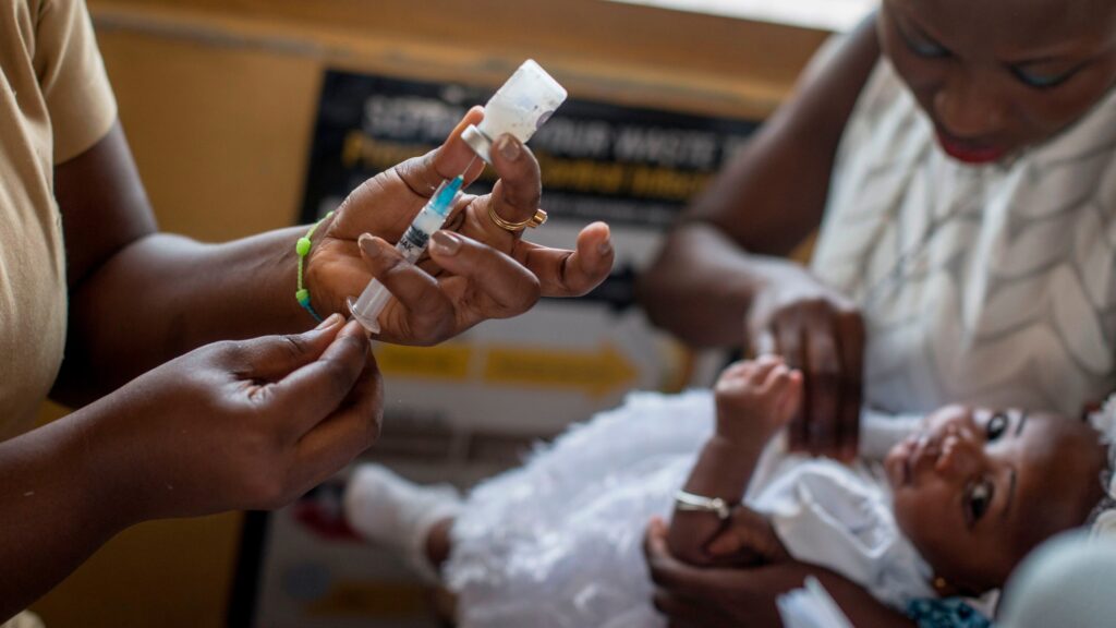 Health worker vaccinating child with malaria vaccine