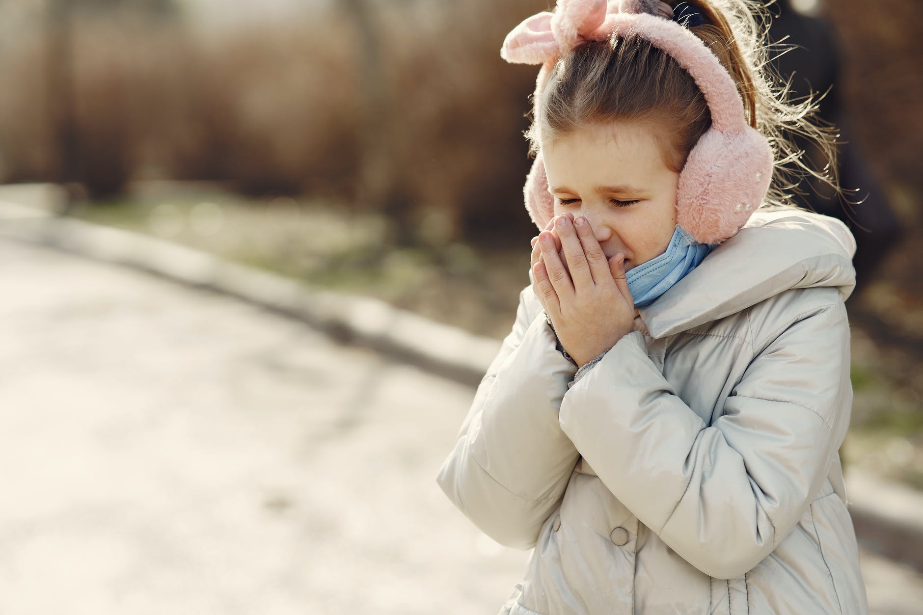 shallow focus photo of a girl sneezing